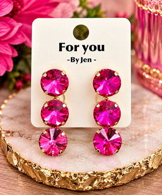 Hot pink crystal triple drop earrings with gold prong settings on display card