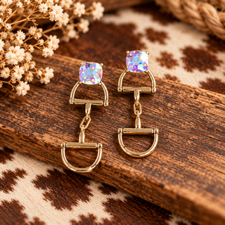 Gold dangle earrings with iridescent cushion-cut crystals and horse spur hardware drops