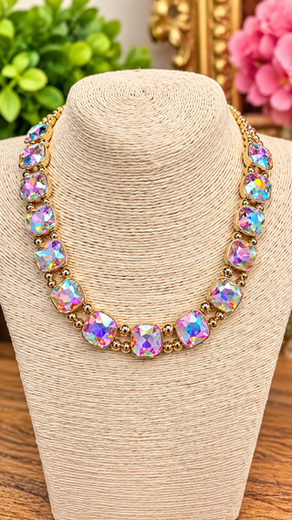 Iridescent AB crystal collarette necklace with gold-tone bezels and bead accents on display bust