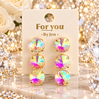 Triple graduated iridescent crystal drop earrings in gold-tone prong settings on display card
