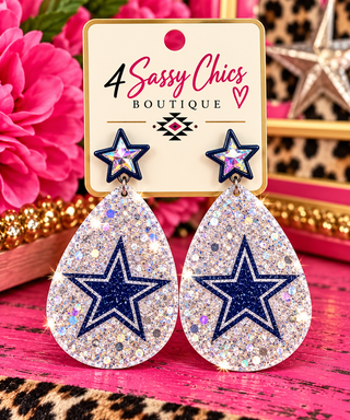 Silver glitter teardrop dangle earrings with navy star design on boutique card