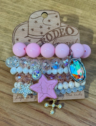Pink beaded stretch bracelet set with star cross charms on Rodeo Cowgirl display card