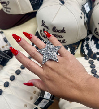 Oversized silver pavé rhinestone star cocktail ring on hand with red nails