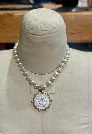 Pearl beaded necklace with gold bezel vintage silver coin pendant on mannequin