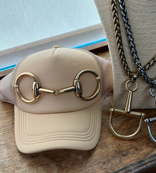 Tan foam trucker cap with gold-tone equestrian snaffle bit hardware on front panel