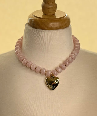 Pink beaded choker necklace with large gold puffy heart pendant on mannequin