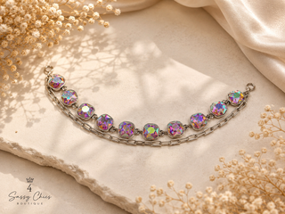 Aurora borealis crystal bracelet with silver chain links on marble surface
