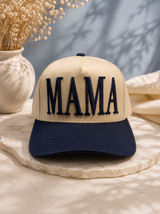 Khaki and navy two-tone snapback cap with bold navy puff-embroidered MAMA lettering