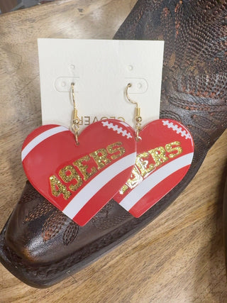Red and white heart-shaped 49ers dangle earrings with gold glitter lettering on card