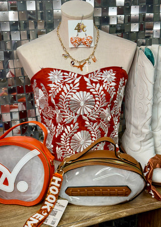 Burnt orange strapless corset top with white floral embroidery on mannequin
