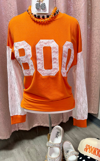 Orange waffle-knit pullover top with white lace sleeves and BOO graphic letters