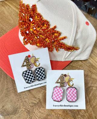 Octagonal checkerboard stud earrings in black-white and pink, displayed on branded cards