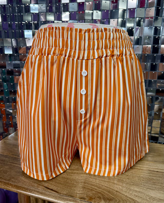 Orange and white vertical striped boxer shorts with elastic waist and button-front placket