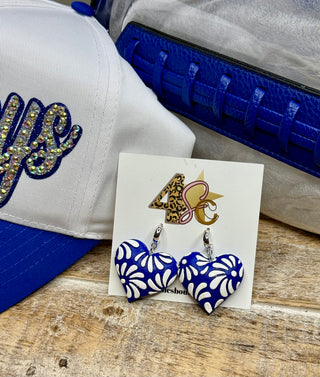 Royal blue heart-shaped dangle earrings with white Talavera floral cutout pattern on display card