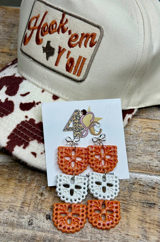 Three-tier orange and white glitter resin papel picado dangle earrings with silver bow studs