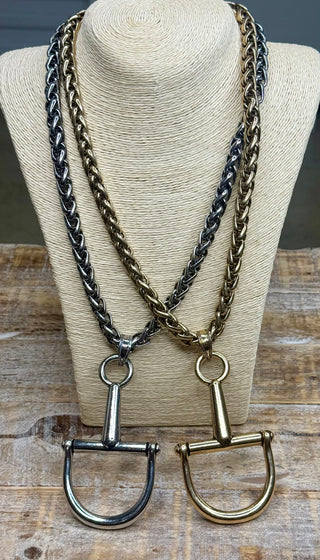 Silver and gold braided chain necklaces with horse bit pendants on display bust