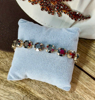 Silver-tone bracelet with round black and dark crystal rhinestones on velvet pillow