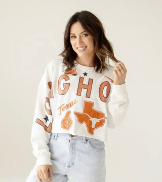 White cropped sweatshirt with Texas Longhorns graphics, worn with light wash jeans