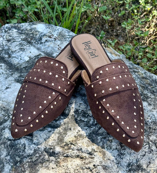 Corkys Mischief brown suede studded mules with pointed toe on rock