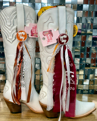 White cowboy boots with game day acrylic medallion charms and ribbon lace fabric boot ties