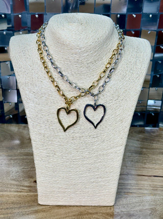 Gold and silver open-heart pendant chain necklaces displayed on cream jewelry bust