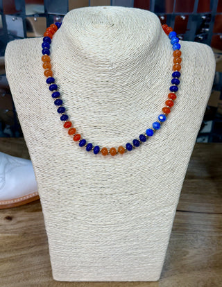 Blue and orange faceted rondelle bead necklace with gold spacers on display bust