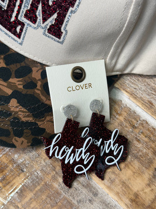 Maroon glitter Texas-shaped dangle earrings with white Howdy script on Clover card