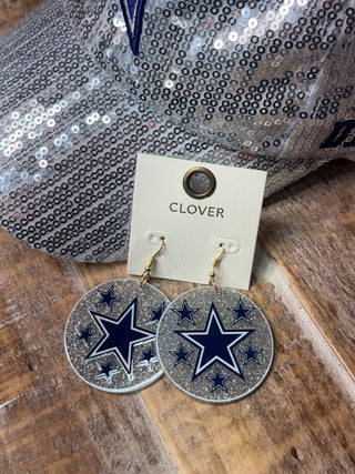 Silver glitter round drop earrings with navy blue star motifs on jewelry card