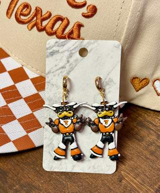 Bevo mascot charm earrings in orange and black on marble display card