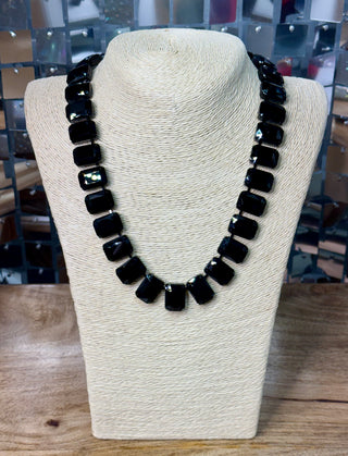 Graduated black faceted rectangular bead statement necklace on cream jewelry bust