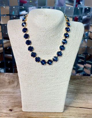 Navy blue round crystal statement necklace with gold prong settings on bust display
