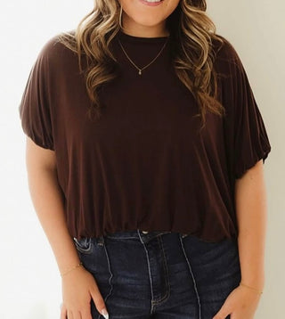 Brown blouson top with elasticized hem, mock neckline, and gathered cap sleeves