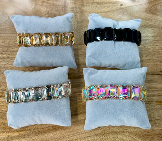 Four stretch bracelets with faceted rectangular stones in champagne, black, clear, and iridescent