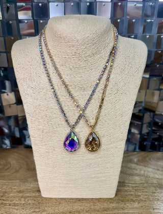 Two crystal teardrop pendant necklaces, one purple iridescent and one champagne gold