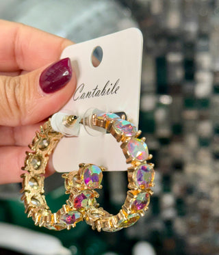 Gold hoop earrings with iridescent cushion-cut crystal stones on white jewelry card