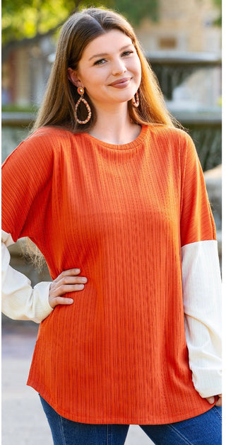 Womens burnt orange ribbed color-block top with cream balloon sleeves and curved hem