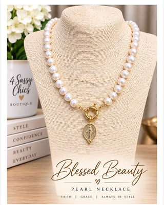 White freshwater pearl necklace with gold Miraculous Medal pendant on jewelry bust