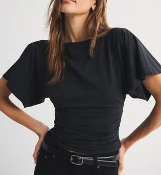 Black flutter sleeve ruched fitted top with boat neckline on woman