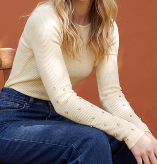 Cream ribbed knit sweater with pearl and rhinestone embellishments on long sleeves