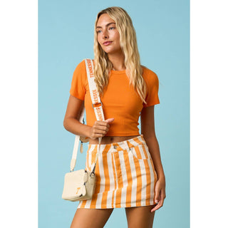 Orange and white striped mini skirt with orange crop top and crossbody bag