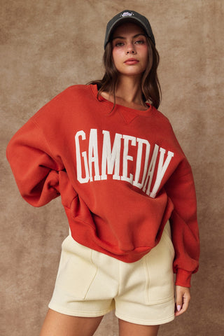 Burnt orange oversized Game Day crewneck sweatshirt with white varsity block letter appliqué